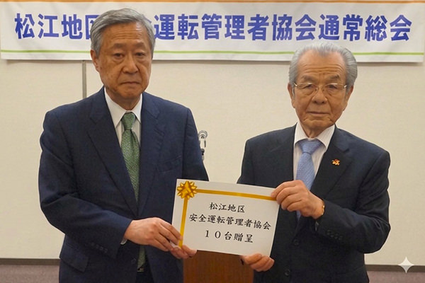 松江地区安全運転管理者協会からチャイルドシートをいただく様子